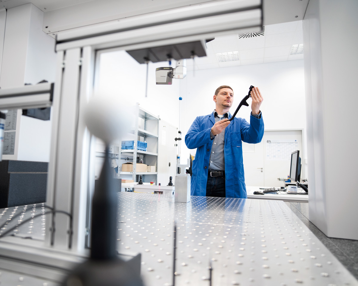 Thorsten Bundschuh, a metrology engineer, prepares to measure a tension lever for a convertible roof.